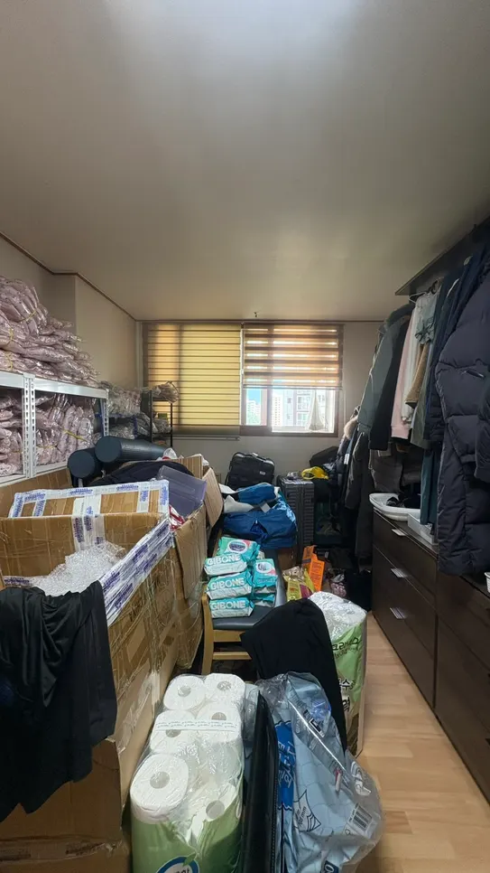 상자와 옷이 쌓여 문까지 막은 방